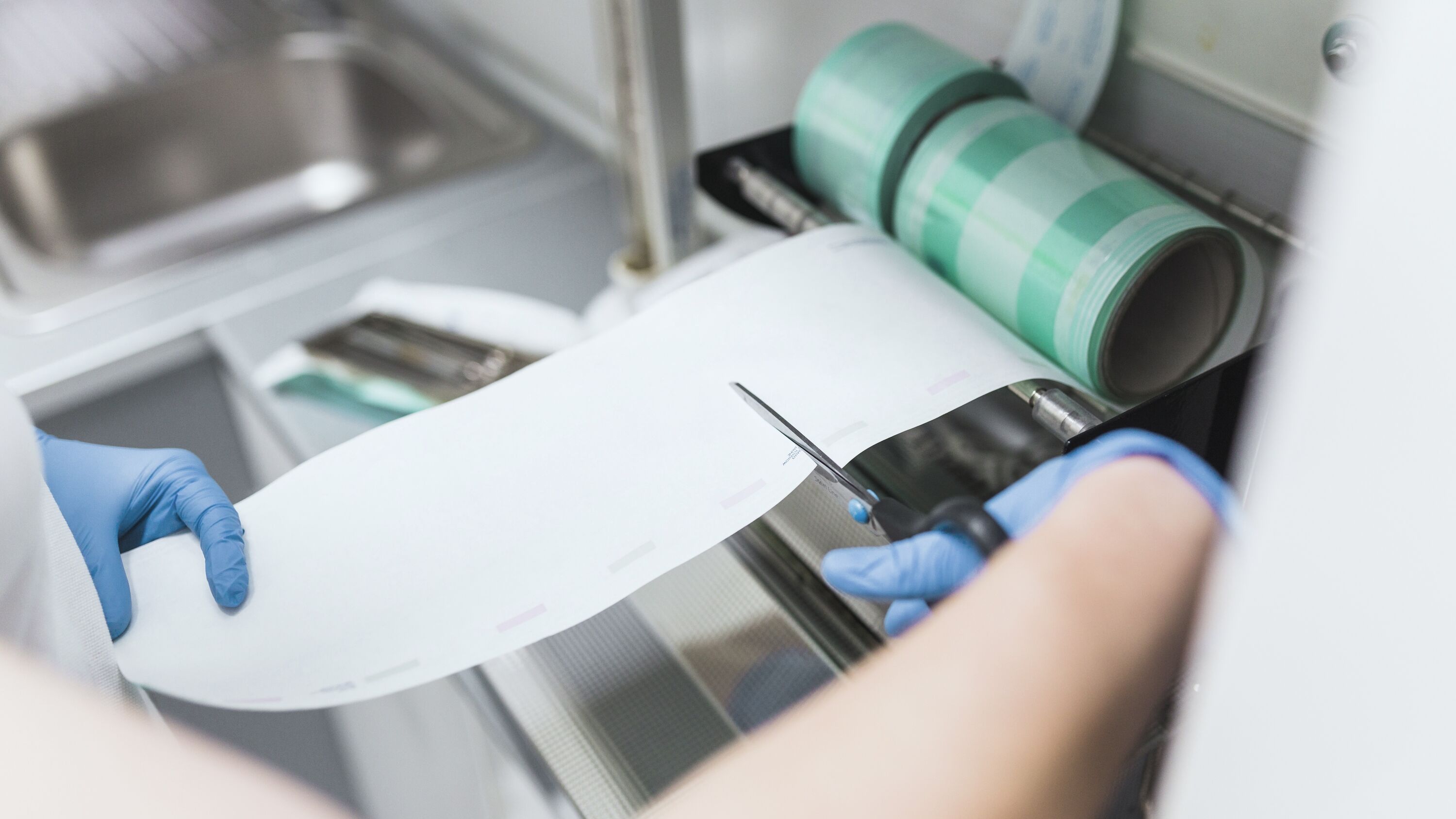 nurse-cutting-plastic-from-pouch-sealer-packaging-machinery (1) 標籤用途介紹|成捲貼紙、瓶標、封口、燙金與防偽變動資料